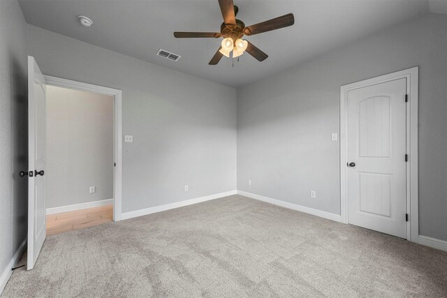 unfurnished room featuring lofted ceiling, ceiling fan, and light carpet