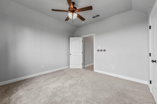 carpeted spare room featuring lofted ceiling and ceiling fan