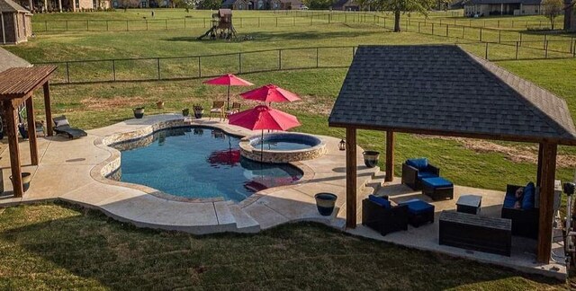 view of swimming pool featuring a patio area, a lawn, an in ground hot tub, a gazebo, and an outdoor living space