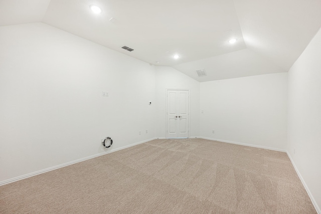 carpeted empty room featuring lofted ceiling