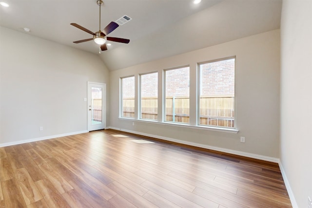 empty room featuring vaulted ceiling, light hardwood / wood-style floors, and ceiling fan