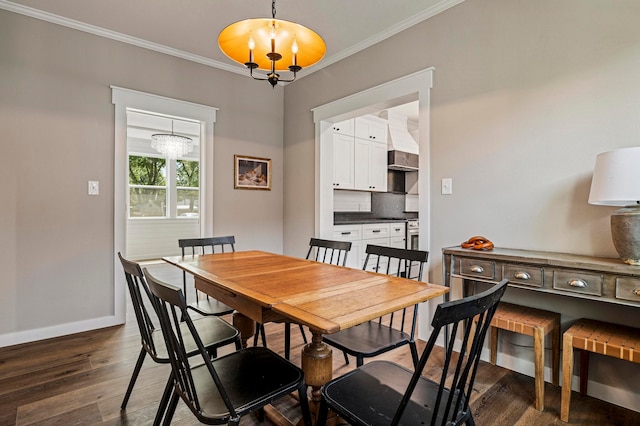 dining space with dark wood-type flooring, crown molding, and an inviting chandelier