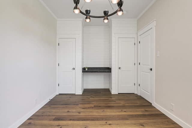 hall featuring an inviting chandelier, ornamental molding, and dark hardwood / wood-style flooring