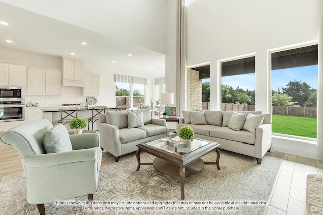 living room with light hardwood / wood-style floors and a high ceiling