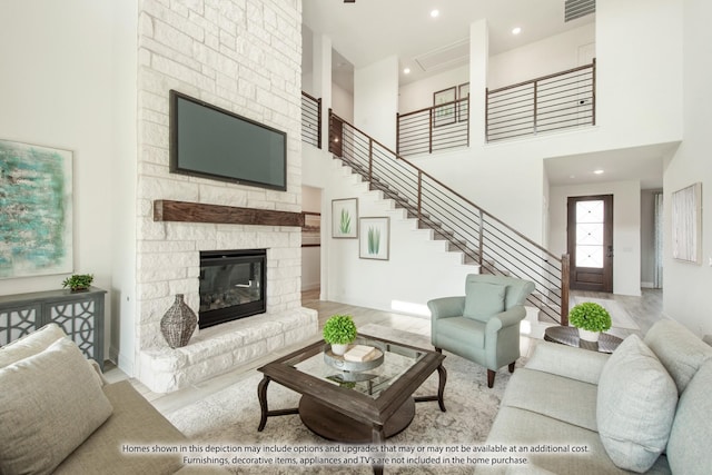 living room with a towering ceiling and a stone fireplace