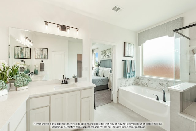 bathroom with a bath, vanity, and tile patterned floors