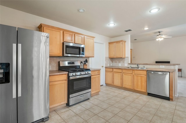 kitchen with appliances with stainless steel finishes, backsplash, light tile flooring, and ceiling fan