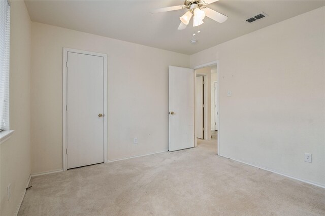 unfurnished bedroom with light colored carpet and ceiling fan