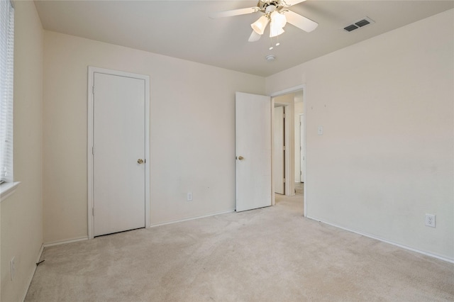 unfurnished bedroom featuring light colored carpet and ceiling fan