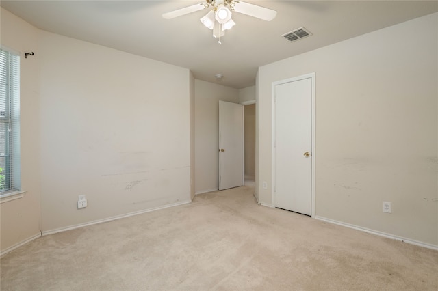 carpeted spare room featuring ceiling fan