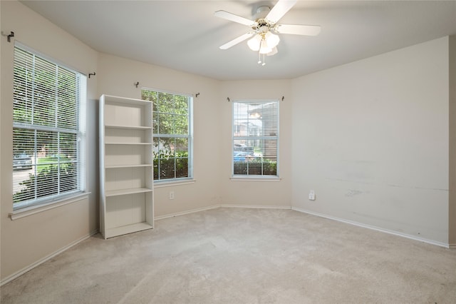 spare room featuring ceiling fan and light carpet