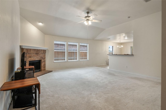 unfurnished living room with vaulted ceiling, ceiling fan with notable chandelier, carpet floors, and a fireplace