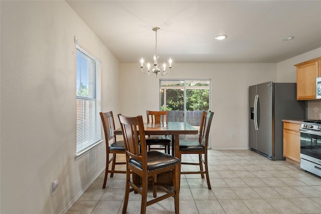 dining area featuring a chandelier and light tile floors