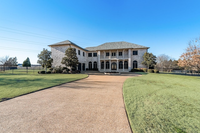 view of front of home with a front lawn and a balcony