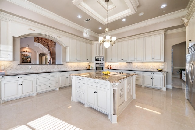 kitchen with a kitchen island, appliances with stainless steel finishes, pendant lighting, dark stone countertops, and ornamental molding