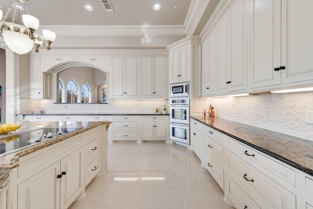 kitchen featuring crown molding, tasteful backsplash, black electric cooktop, stainless steel microwave, and dark stone counters