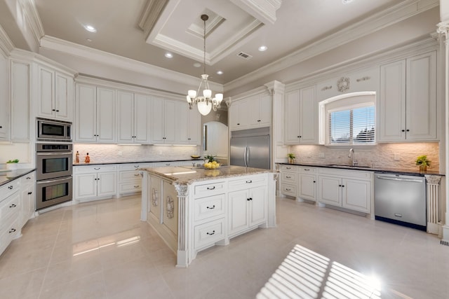 kitchen with sink, built in appliances, a kitchen island, pendant lighting, and decorative backsplash