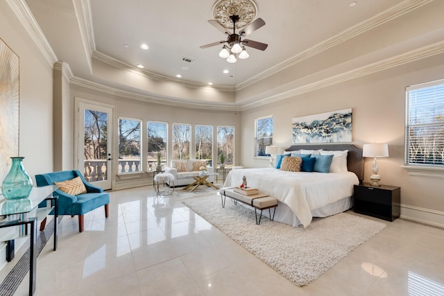 tiled bedroom with a raised ceiling, ceiling fan, and multiple windows