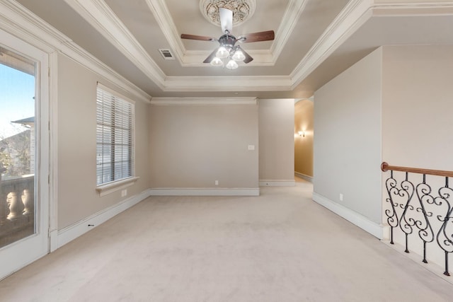 carpeted empty room with crown molding, ceiling fan, and a raised ceiling