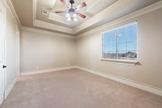 carpeted empty room featuring crown molding, ceiling fan, and a tray ceiling