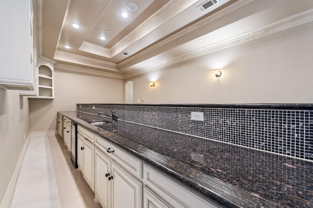 kitchen with light tile patterned flooring, sink, dark stone countertops, white cabinets, and a tray ceiling