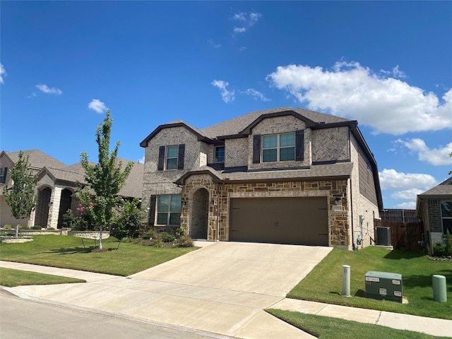 view of front of property with a garage, a front yard, and central AC