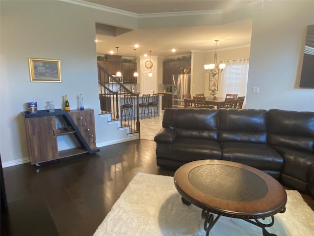 living room featuring crown molding, dark hardwood / wood-style flooring, and a chandelier