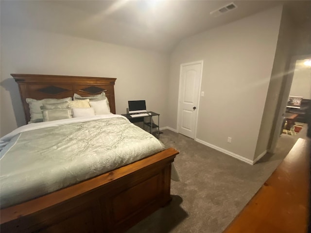 bedroom with dark colored carpet and vaulted ceiling