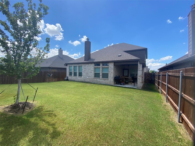 back of house with a yard and a patio