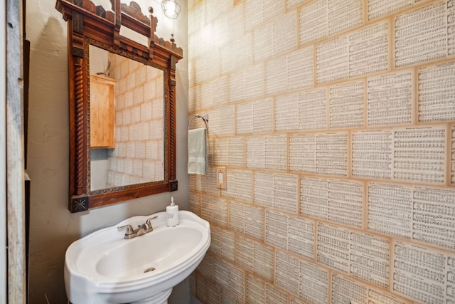 bathroom featuring tile walls and sink