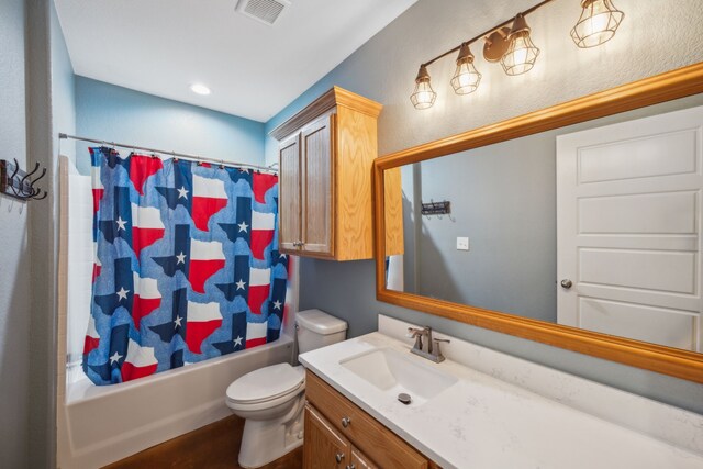 full bathroom with vanity, shower / bath combo with shower curtain, and toilet