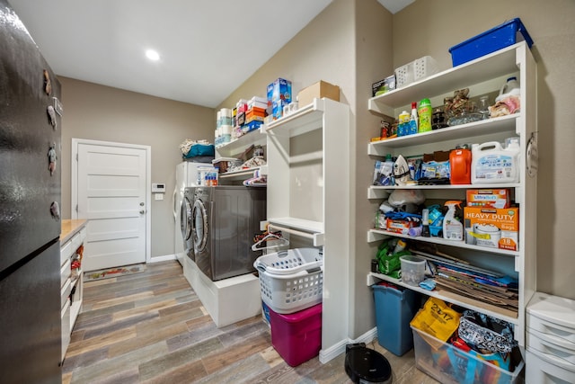 laundry area with washer and clothes dryer and hardwood / wood-style floors