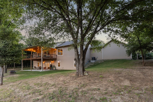 rear view of house with a lawn, a deck, and a patio area