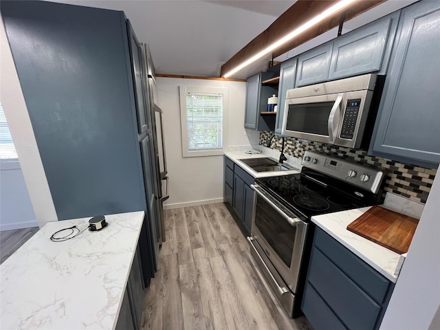 kitchen featuring sink, light hardwood / wood-style flooring, ornamental molding, appliances with stainless steel finishes, and tasteful backsplash