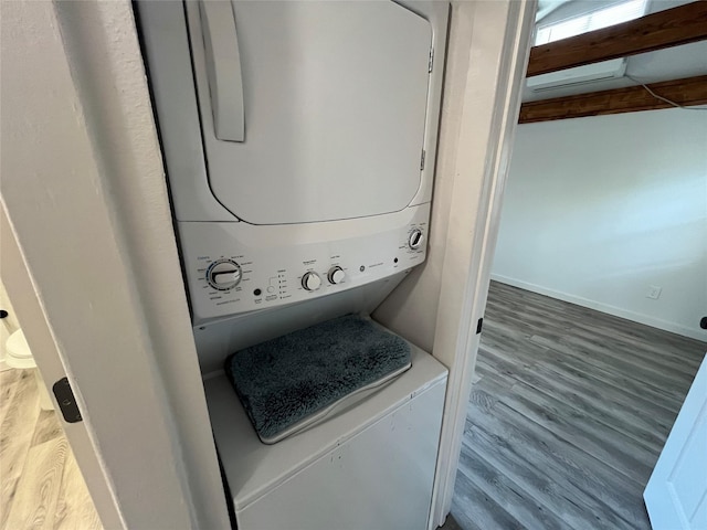 laundry area with stacked washer and dryer and hardwood / wood-style flooring