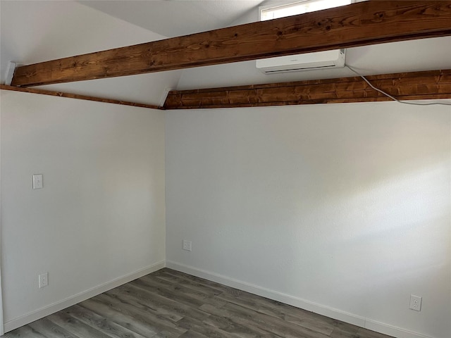 empty room featuring hardwood / wood-style floors, vaulted ceiling with beams, and a wall mounted AC