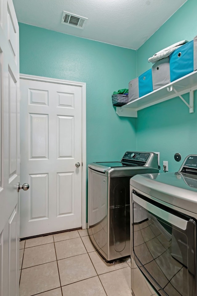 laundry room with separate washer and dryer and light tile patterned floors