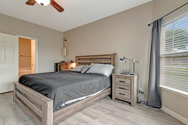 bedroom featuring light wood-type flooring, ceiling fan, and ensuite bathroom