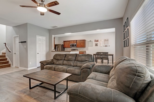 living room with light hardwood / wood-style floors and ceiling fan