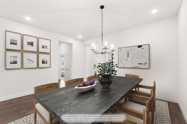 dining room with dark hardwood / wood-style flooring and a notable chandelier