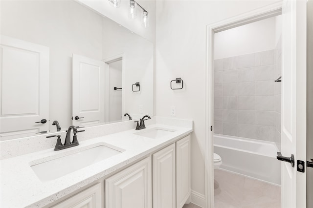 full bathroom with tiled shower / bath, vanity, and toilet