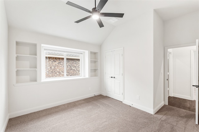 carpeted empty room with ceiling fan, lofted ceiling, and built in features