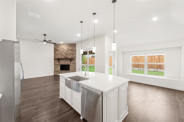 kitchen featuring appliances with stainless steel finishes, white cabinets, a kitchen island with sink, dark hardwood / wood-style floors, and sink