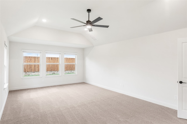 carpeted spare room with ceiling fan and vaulted ceiling