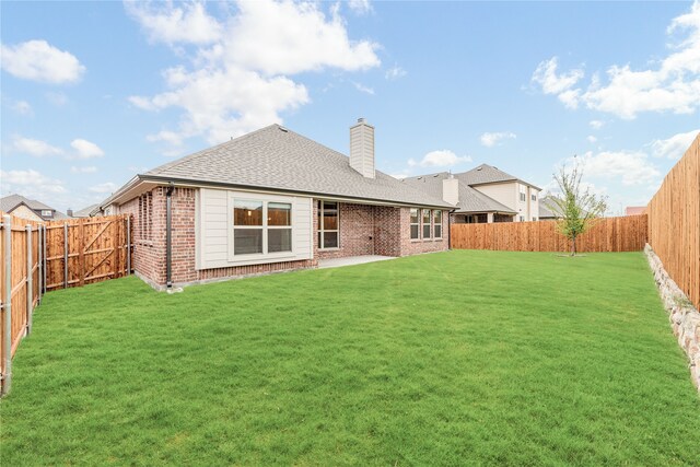 rear view of property featuring a lawn and a patio area