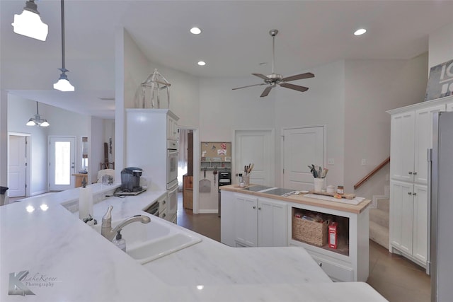 kitchen with white cabinets, sink, white appliances, and hanging light fixtures