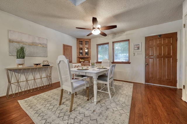 dining space with a textured ceiling, hardwood / wood-style flooring, and ceiling fan