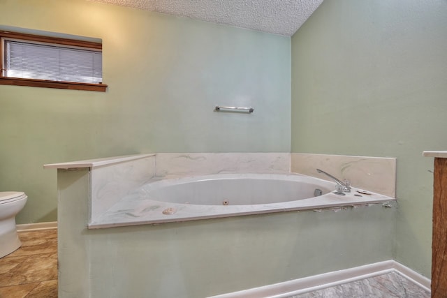 bathroom featuring toilet, a textured ceiling, and a tub