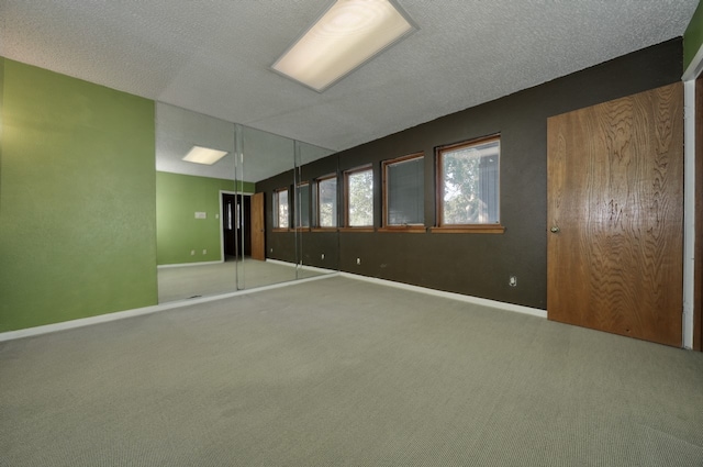 carpeted spare room featuring a textured ceiling