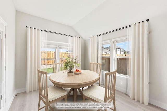 dining room featuring light hardwood / wood-style flooring and vaulted ceiling